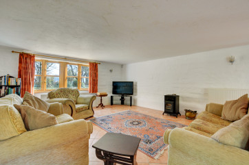 Large comfortable seating area with a window looking out to the garden.