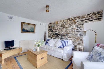 Sitting room with comfortable sofas, TV and woodburning stove