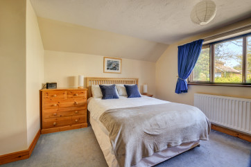 Light and airy double bedroom with a with a king-size bed and washbasin - please note there are two or three steps from hallway up to this bedroom 