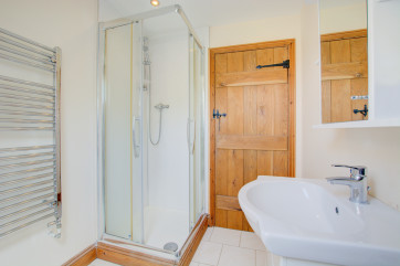 En-suite with shower cubicle and heated towel radiator.