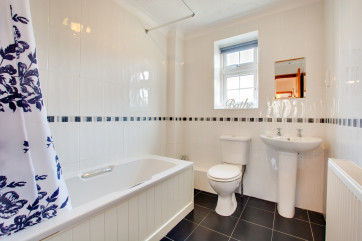 Bathroom with bath, shower over, sink and wc