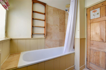 Bathroom with bath, over bath electric shower, wash hand basin and wc.