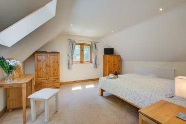 A large room with double bed, velux window and window to garden.