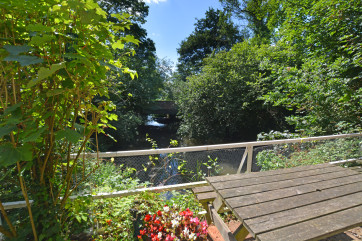 A pleasant outlook from the outside sitting area to the bridge over the stream.