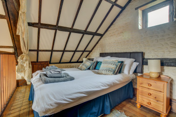 This charming double bedroom with a double bed is full of character with exposed beams, wooden floors and pine storage