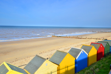 Multi-coloured beach huts adorn the sea front.
