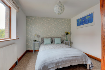 Contemporary furniture and furnishings in this bright double bedded second bedroom.