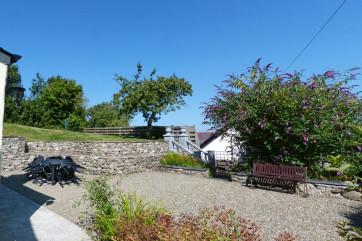 Side garden and BBQ area with table and chairs