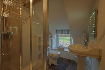 Bedroom 1 en-suite with shower, toilet, basin and heated towel rail. 