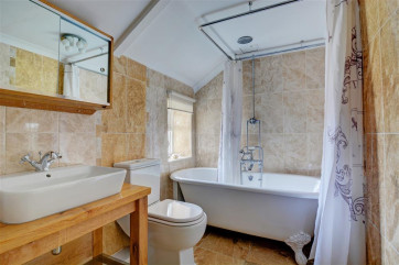 Beautiful bathroom with roll top bath and over bath shower