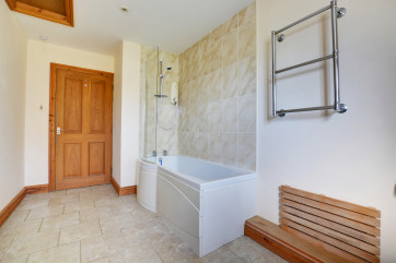 This family bathroom is very spacious and has a bath with over bath shower