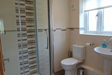 En suite facilities include an enclosed shower cubicle, WC and wash basin.