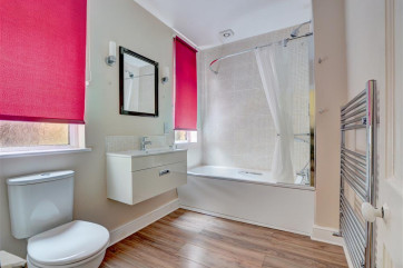Spacious bathroom with brightly coloured blinds