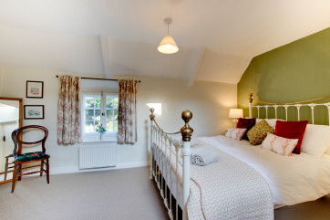 Light and bright, the king size bed room has lovely views to the church beyond
