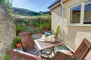 The compact kitchen sits to the rear with a door to a small, private, peaceful patio-style outdoor space