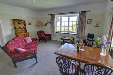 The living room has a cottage suite and oak dining table and chairs