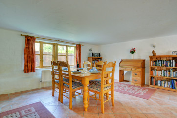 A pine table and six chairs stand in the centre of the large dining area, perfect for family meals