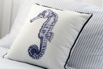 Decorative seahorse cushions have been placed on the twin beds to add pretty little touches to the room