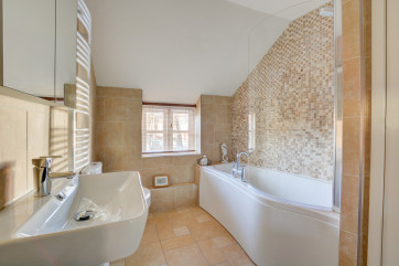 Modern tiled bathroom with bath and overbath shower