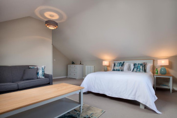 Upstairs master king-size bedroom with en-suite shower room, TV, sofa bed & glass doors opening out onto a sunny balcony