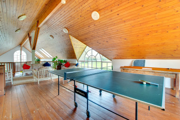 Indoor balcony overlooking pool with conservatory furniture, fridge, table tennis & shuffleboard.