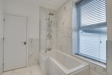 Master bathroom with shower over bath