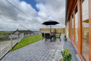 The property benefits from a large patio and grass area, perfect for taking in the views