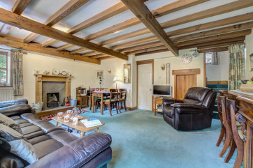 Spacious lounge and dining area with open fire and beamed ceiling