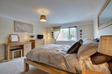 The stylish master bedroom with double bed and TV