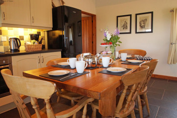 Unit 2: Beudy A spacious, cream 'shaker' style kitchen with a farmhouse pine table.