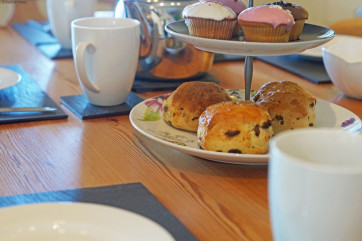 A spacious, cream 'shaker' style kitchen with a farmhouse pine table.