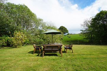 Garden furniture in a private setting with countryside views.