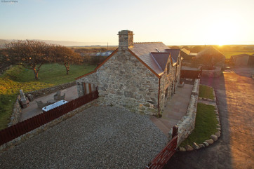 Hafod cottage with the sun setting over the sea