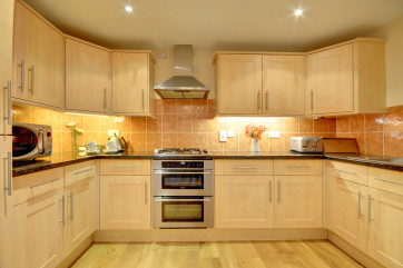 Maple units and granite style work surfaces complement the kitchen and dining areas to the rear