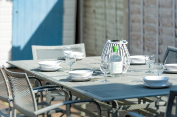 All sit down together and enjoy a meal out in the garden on the contemporary dining table and chairs