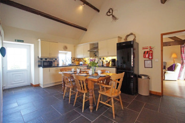 A spacious, cream 'shaker' style kitchen with a farmhouse pine table.