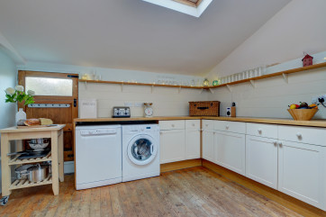 The well-equipped large kitchen with low ceiling in parts, original wooden floors, breakfast bar and large range cooker