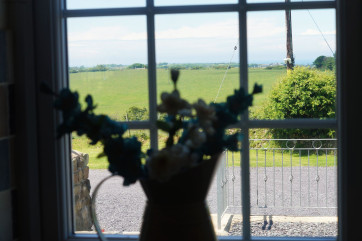 A spacious, cream 'shaker' style kitchen with a farmhouse pine table.