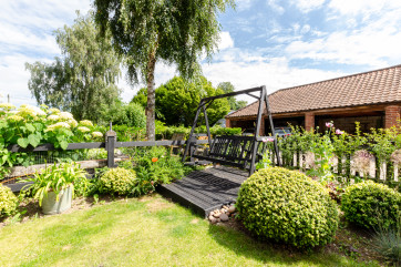 Lawned garden with shrubbery and a swing seat