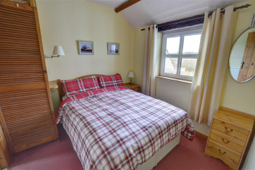 Comfy looking double bed, with fitted wardrobe and bedside cabinets