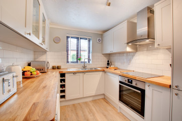 Modern and well equipped the kitchen is bright with lovely views into the garden