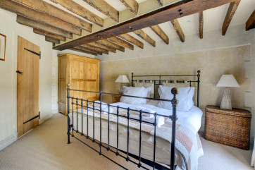 The main bedroom has stunning open beams and bare brick features.