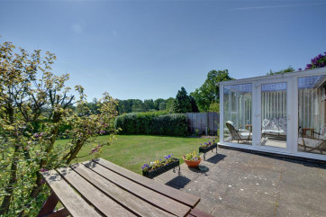 With plenty of outside space this patio can be enjoyed around this wooden picnic table.