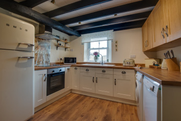Well-equipped kitchen, beamed ceiling and views over the Hawes bridge and waterfall