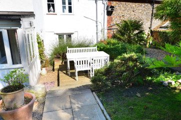 Fully enclosed lawned garden with a patio area, garden furniture and a barbecue, ideal for al fresco dining 
