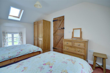 Twin beds with wardrobe and chest of draws.