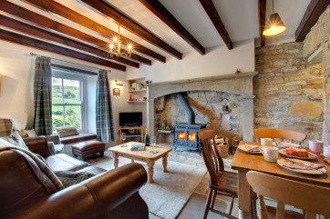 A cosy lounge with woodburning stove and beamed ceiling