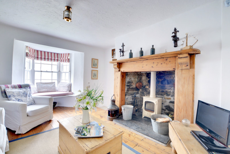 The sitting room has a cosy wood burning stove and an alcoved window seat