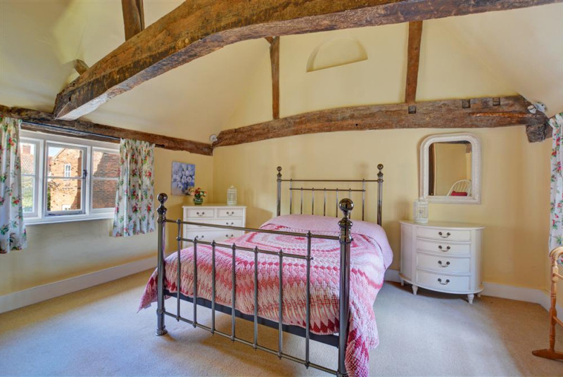 Bright, pretty and spacious bedroom with exposed beams.