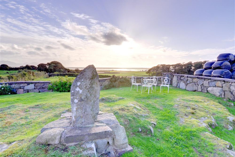 The little side garden has a standing stone feature, and garden furniture overlooking the distant sea view, often with spectacular sunsets